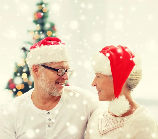 Glückliches Senioren-Paar mit Weihnachtsmann-Helfermützen zu Hause — Stockfoto