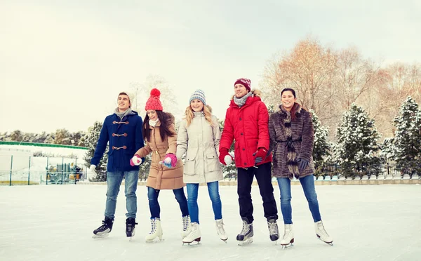 Happy vänner skridskoåkning på isbanan utomhus — Stockfoto