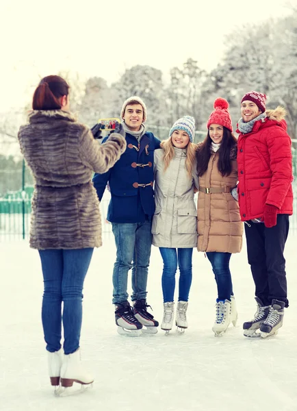 Mutlu arkadaş grubu buz buz pateni pisti smartphone — Stok fotoğraf