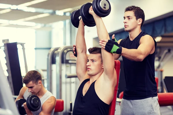 Groupe d'hommes avec haltères dans la salle de gym — Photo