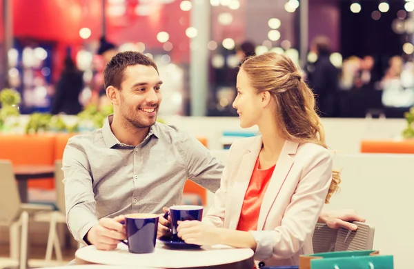 Coppia felice con borse della spesa bere caffè — Foto Stock