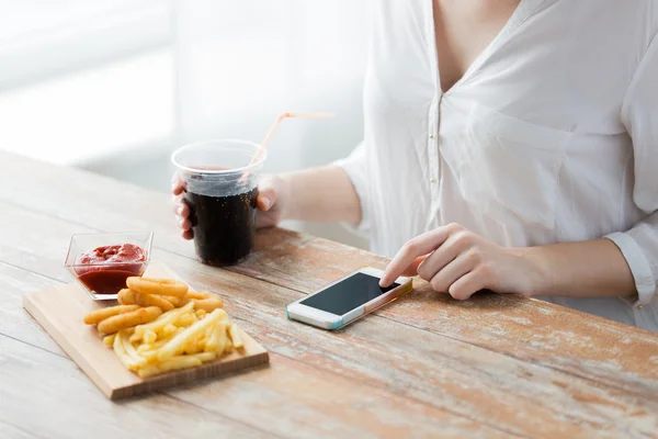 Close up of woman with smart phone and fast food — Stock Photo, Image