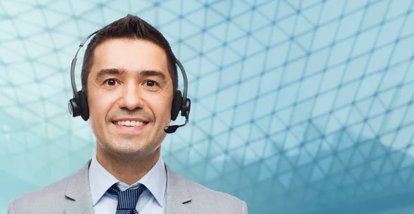 Happy businessman in headset over grid background — Stockfoto