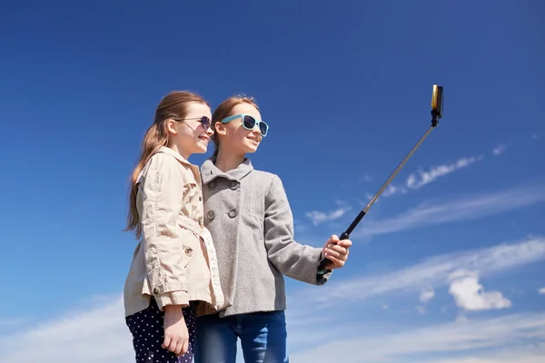 Szczęśliwy dziewcząt z smartphone selfie kij — Zdjęcie stockowe