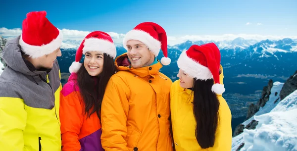 Happy vrienden in santa hoeden en skipakken buitenshuis — Stockfoto