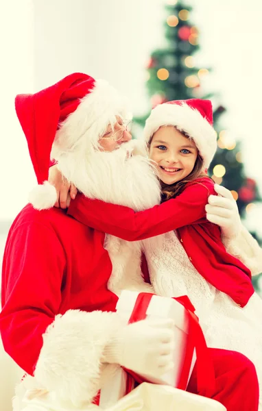 Lachende meisje met santa claus — Stockfoto