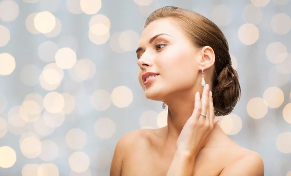 Hermosa mujer con pendientes de diamantes y pulsera — Foto de Stock