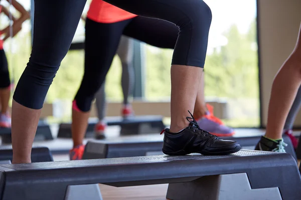 Gros plan des femmes faisant de l'exercice avec des steppers dans la salle de gym — Photo