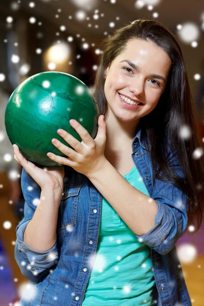 Šťastná mladá žena drží míč v bowling Clubu — Stock fotografie