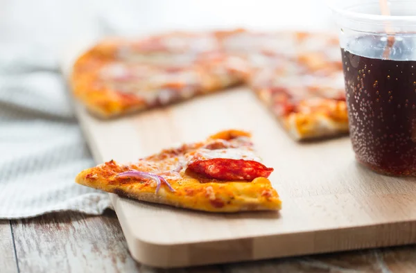 Close up of pizza with carbonated drink on table — 스톡 사진