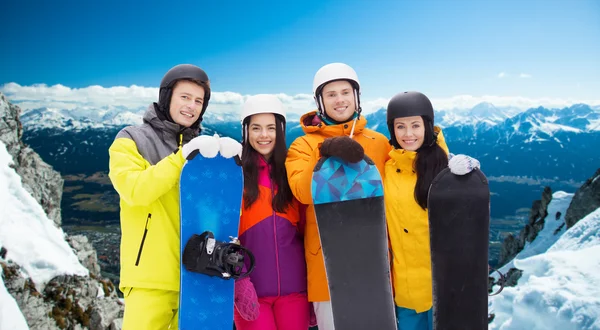 Happy vrienden in helmen met snowboards buitenshuis — Stockfoto