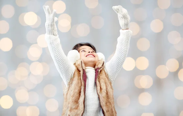 Glückliches kleines Mädchen mit Ohrenschützern über Feiertagsbeleuchtung — Stockfoto