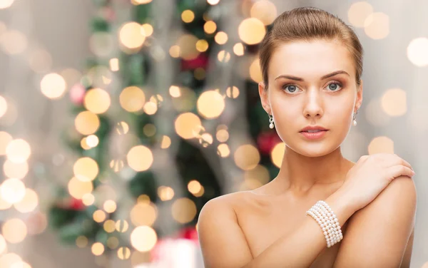 Mooie vrouw met parel oorbellen en armband — Stockfoto
