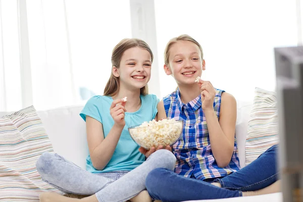 Meninas felizes com pipocas assistindo tv em casa — Fotografia de Stock