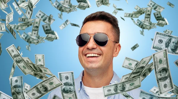 Hombre feliz en gafas de sol con dinero cayendo dólar —  Fotos de Stock