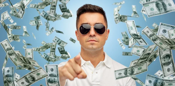 Человек, указывающий на вас падающими долларовыми деньгами — стоковое фото