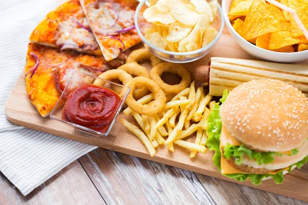 Close up of fast food snacks on wooden table — Stock Photo, Image