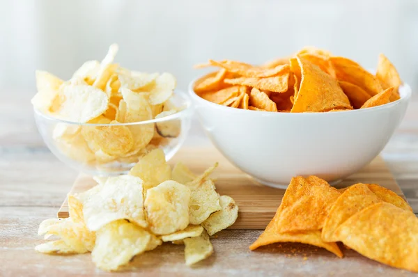 Close up of potato crisps and nachos in glass bowl — Stock fotografie