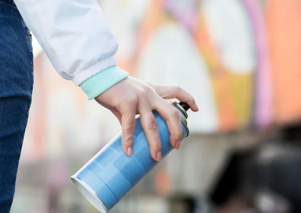 Close up of hand holding spray paint and graffiti — Stock Photo, Image