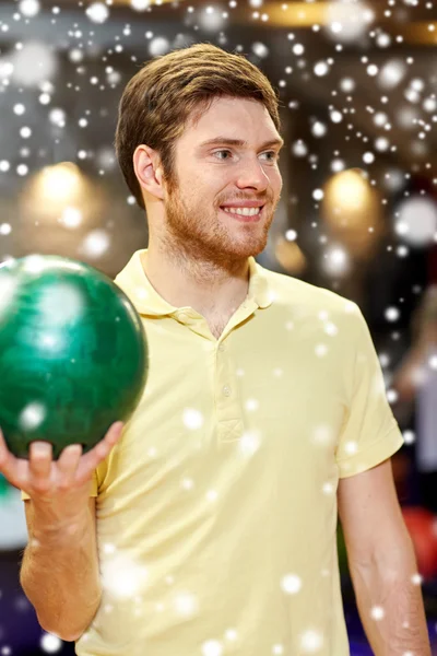 Счастливый молодой человек держит мяч в боулинг-клубе — стоковое фото