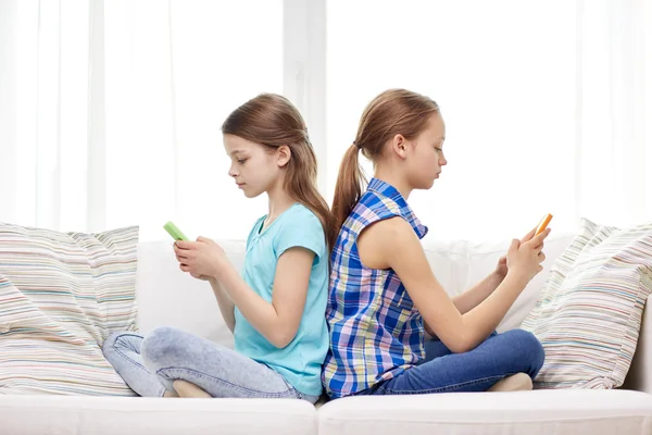 Девушки со смартфонами сидят дома на диване — стоковое фото