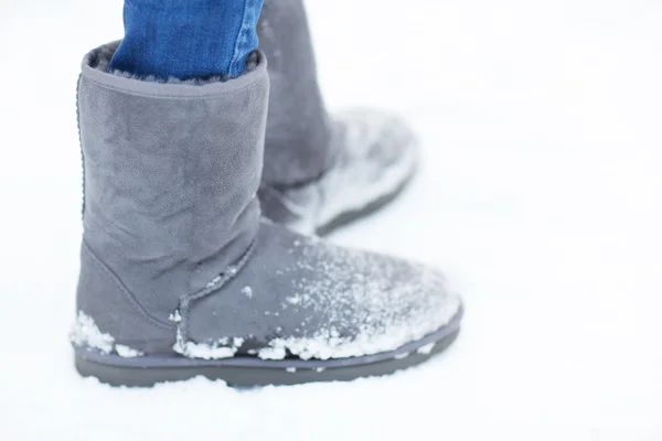 Close up of woman legs wearing warm boots on snow — ストック写真