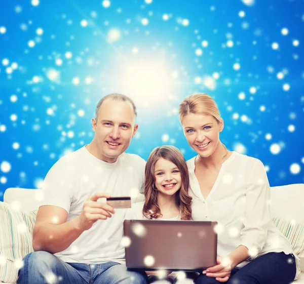 Familia feliz con ordenador portátil y tarjeta de crédito —  Fotos de Stock