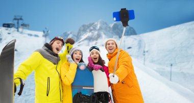 happy friends with snowboards and smartphone clipart