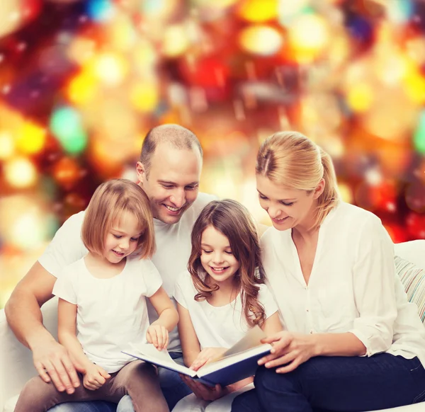 Família feliz com livro em casa — Fotografia de Stock