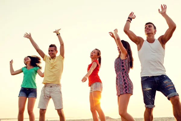 Amigos sonrientes bailando en la playa de verano — Foto de Stock