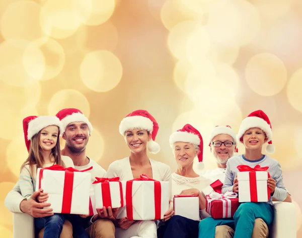 Happy family in santa helper hats with gift boxes — Stock Photo, Image