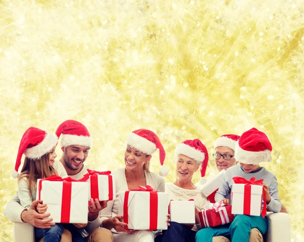 Família feliz em santa helper chapéus com caixas de presente — Fotografia de Stock