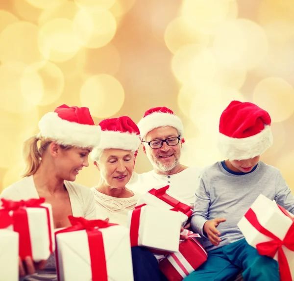 Happy family in santa helper hats with gift boxes — Stock Photo, Image