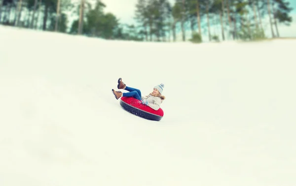 Menina adolescente feliz deslizando para baixo no tubo de neve — Fotografia de Stock