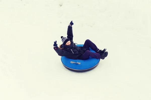 Feliz joven deslizándose hacia abajo en el tubo de nieve —  Fotos de Stock