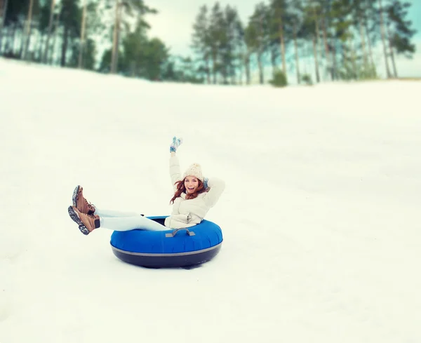 Menina adolescente feliz deslizando para baixo no tubo de neve — Fotografia de Stock