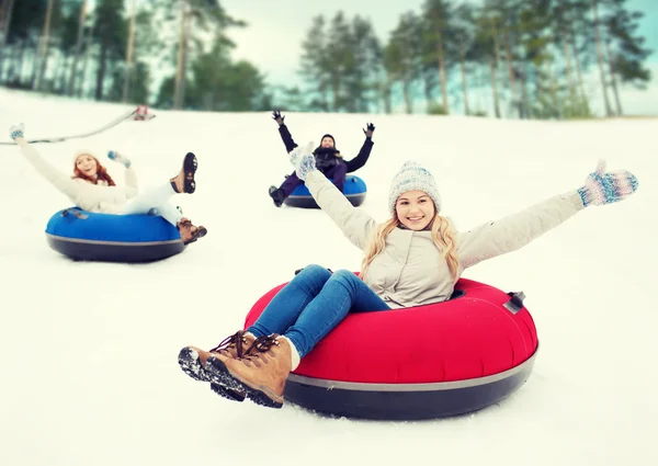 Group of happy friends sliding down on snow tubes — Stock Photo, Image