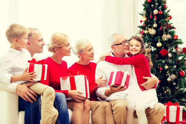 Família sorridente com presentes em casa — Fotografia de Stock