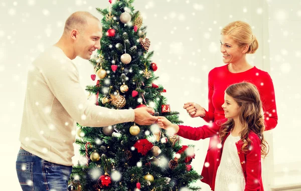 Smiling family decorating christmas tree at home — Stock Photo, Image