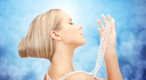 Bella donna con collana di perle di mare su blu — Foto Stock