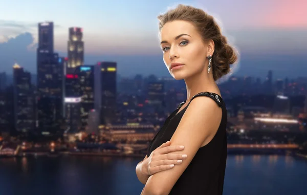 Beautiful woman wearing earrings over night city — Stockfoto