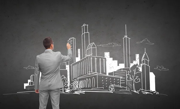 Businessman drawing city sketch from back — Stock Photo, Image