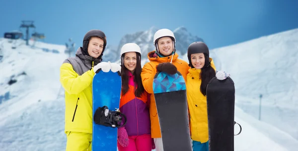 Happy friends in helmets with snowboards outdoors — Stock Photo, Image