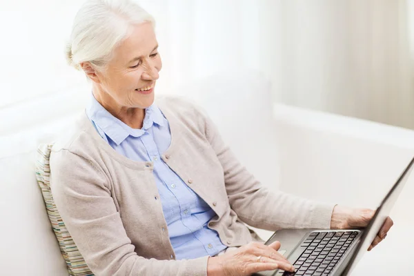 Mulher sênior feliz com laptop em casa — Fotografia de Stock