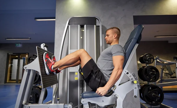 Homme flexion des muscles des jambes sur la machine de gymnase — Photo