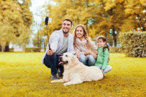 Щаслива сім'я з собакою, яка приймає селфі за допомогою смартфона — стокове фото