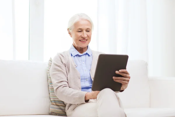 Mulher sênior feliz com tablet pc em casa — Fotografia de Stock