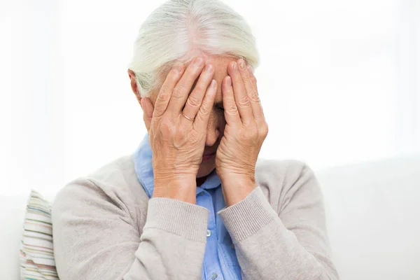Starší žena trpí bolestmi hlavy nebo smutek — Stock fotografie