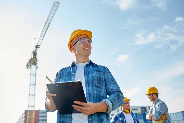 Builder in hardhat with clipboard at construction — Stock Photo, Image