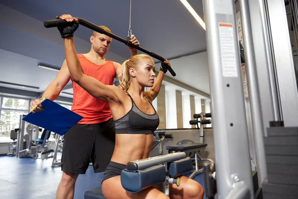 Hombres y mujeres flexionando los músculos en la máquina de gimnasio —  Fotos de Stock